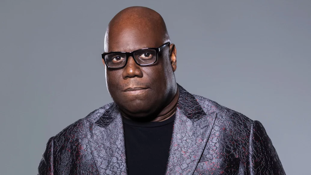 Carl Cox posing in a silver/purple patterned suit